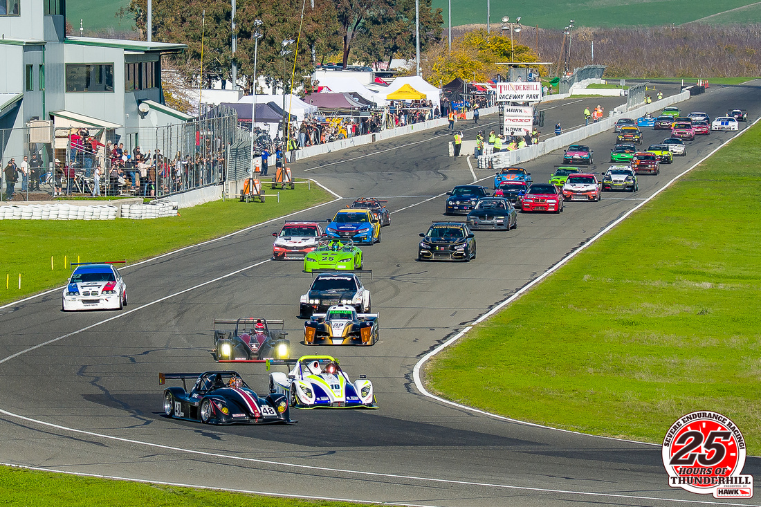 Image of many race cars taking the green flag for the 2021 NASA 25 Hours of Thunderhill at Thunderhill Raceway Park in Willows California. NASA 25 Hours Race